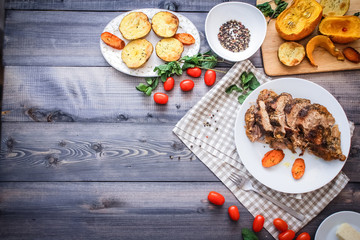 A large piece of baked meat Still life on a light wooden table.