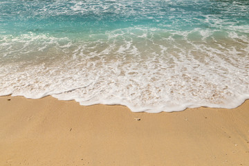 Surf rolling up the beautiful sands of Atuh beach in Nusa penida island in Indonesia.