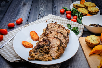 A large piece of baked meat Still life on a light wooden table.