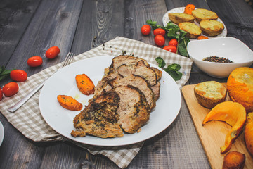 A large piece of baked meat Still life on a light wooden table.