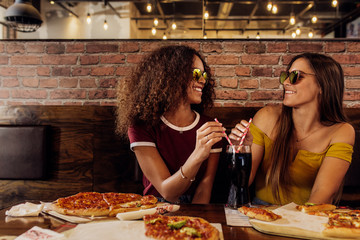 Stylish friends having cold drink at cafe