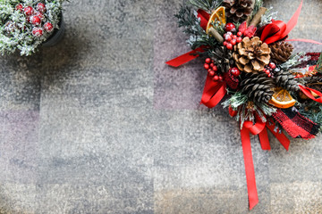 Creative Christmas wreath. An unusual idea for a holiday home decor. Natural interior decor on white background. Slices of oranges, cones, red decoration, leaves of christmas tree