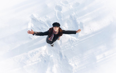 Snow angel concept. Angel wings on the snow. The girl spreading her arms.