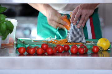 Kucharz kroi marchwekę na sałatkę.	