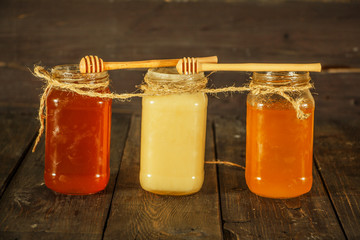 Different types of honey in glass jar on wooden rustic background. Honey in a glass jar. Honey is a healthy diet.