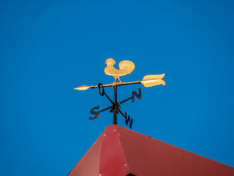 Image of a golden weathercock on a roof