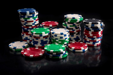 Casino chips in heaps on black table