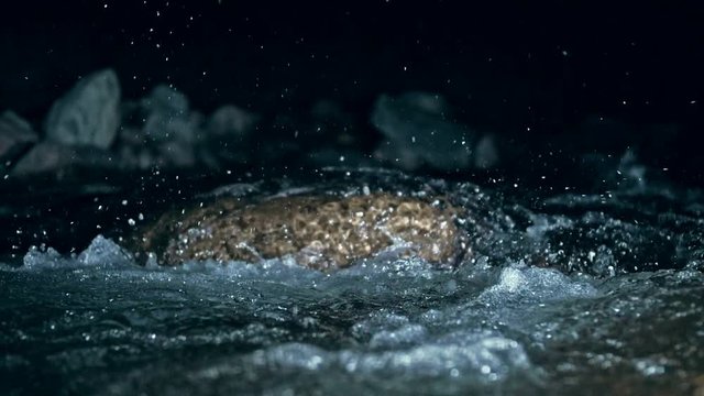 Slow motion of waves on dark water surface with play of flecks of bright light close up. Amazing dramatic natural background. Shooting with 180fps. Epic mystical and magic night view. Crystal clear