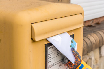 Kind wirft einen Brief in den Briefkasten