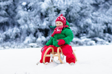 Boy on sleigh ride. Child sledding. Kid with sledge