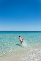 Fototapeta na wymiar Man diving in a beach on the seacoast of Melendugno