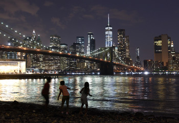 New York City, financial district in lower Manhattan with Brooklin Bridge at night, USA