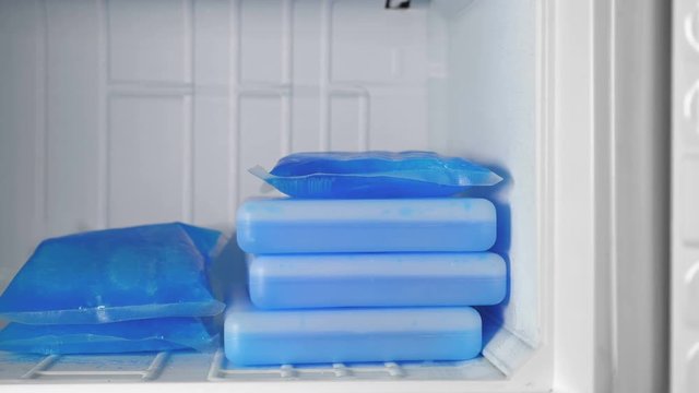 Ice packs of blue color lie in the freezer.