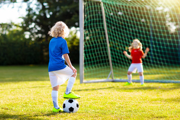 Kids play football. Child at soccer field.