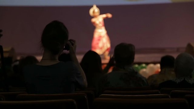 girl shoots dance performance on smartphone at Diwali celebration