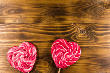 Two heart shaped lollipop on wooden background