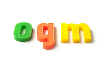 closeup of colorful plastic letters on white background - ogm