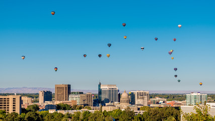 Unique view of the Boise skyline in summer with many hot air balloons floating by
