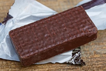 big brown candy cane on a white wrap lying on a brown table