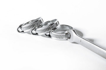 New metal hose clamps with threaded connection for pipes, stainless steel, small size on isolated white background close-up