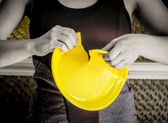 Europe ban on plastic dishes concept. Woman destroys yellow plastic plate. Black and white picture.