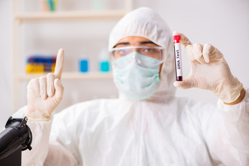 Young handsome lab assistant testing blood samples in hospital 