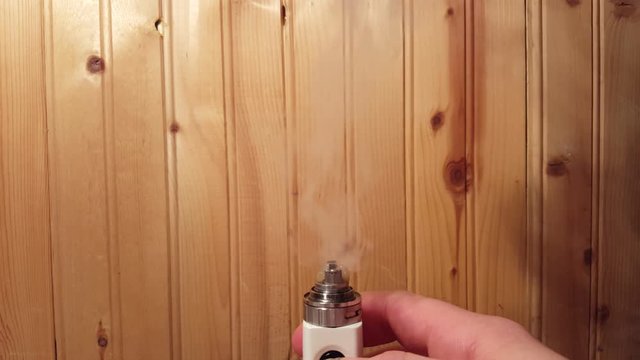 Vape Mod RBA RDA Vaporizing E-Liquid E-Juice.  Close-Up Cotton and Coil Wire With Hand.