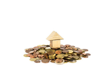 Golden miniature house on the pile of euro coins in the concept of money to buy a home, isolated on...