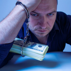Money addiction concept. Businessman chained and shackled to a US Dollars.