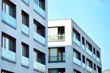  Fragment of a facade of a building with windows and balconies. Modern home with many flats.