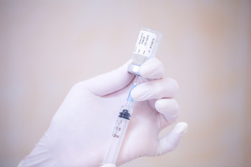 Nurse hand holding a syringe and vial dose with vaccine or drugs, prepares for an injection. Medical concept: vaccination, injection, treatment disease, hospital, immunization, illness, disease.