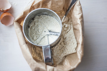 Ingredients for baking cake laid out on a white wooden table. selective focus