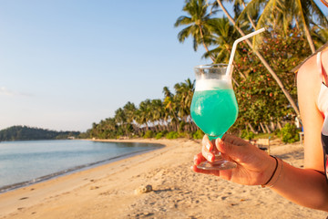 Woman holding Blue Cocktail at Paradise Beach