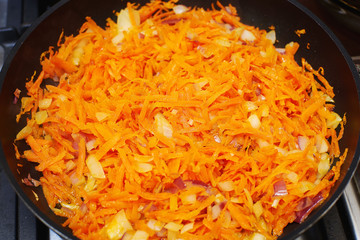 Grated carrot and onion on the frying pan