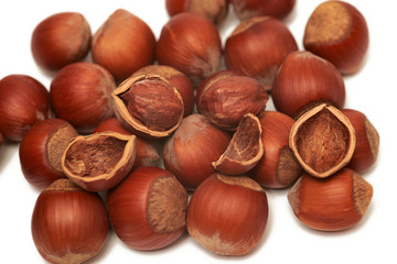 Hazelnuts and brown hazel leaves on white background, isolated, closeup