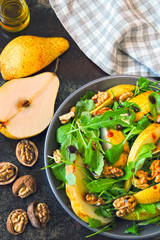 Healthy food bowl. Salad with arugula, pear and walnut. Vegan bowl of colorful salad.