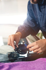 Close-up of a professional windshield repairman working with hydraulic polymer crack filler. Elimination of cracks and chips on windshields