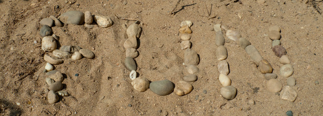 Wort, geschrieben, gelegt, Kiesel, Steinschen, klein, mini, aneinander, Sommer, Sand, Geologie, Urlaub, Ferien, weiß, grau, braun, gelb, ocker, Spiel, Symbol, Freude, Sport, Strand, Meer, Muscheln, Er