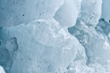 Close-up pieces of ice showered in the ice grotto of a glacier. The destruction of the glacier. Global warming. Small DOF