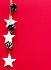 Christmas tree cones, and stars on a red background. Christmas theme. Free space for inscriptions.