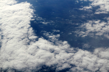 The plane flies high above the clouds. View from the window. Sunny day. Nature Background. Travel concept.