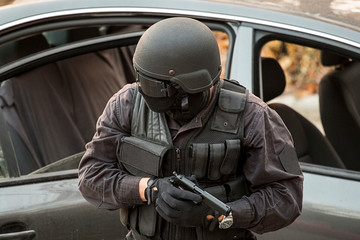 Armed special forces operator in action, pulling over and checking a car
