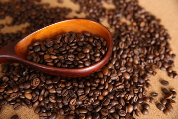 coffee beans in a wooden spoon and on the table