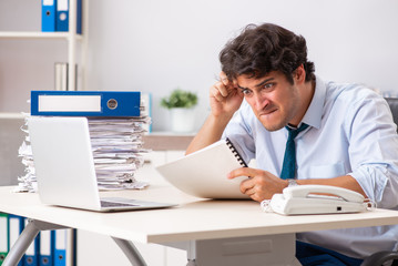 Overloaded busy employee with too much work and paperwork