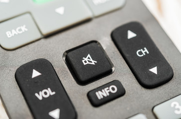 Fototapeta premium Close up macro photography of a smart tv television remote control with volume button. Concept of silence, fake news, and propaganda