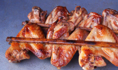 grilled chicken wings / roast BBQ chicken wings with garnish in bamboo stick thai style chicken grilled 