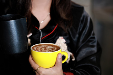 Barista girl dressing latte art on coffee cup