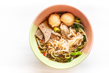 Spicy rice noodles soup in a bowl on white, Thai food, top view of food