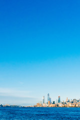 Fototapeta premium Skyline of uptown Manhattan over Hudson River under blue sky, at sunset, in New York City, USA