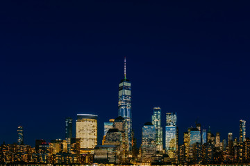Night view of skyline of downtown Manhattan under dark blue sky, in New York City, USA
